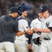 Yankees baseball players and coach conferring.