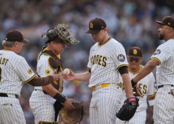 San Diego Padres starting pitcher Michael King, center, hands the ball to manager Mike Shildt (8) as he exits during the third inning of a baseball game against the Boston Red Sox Saturday, Aug. 9, 2025, in San Diego.