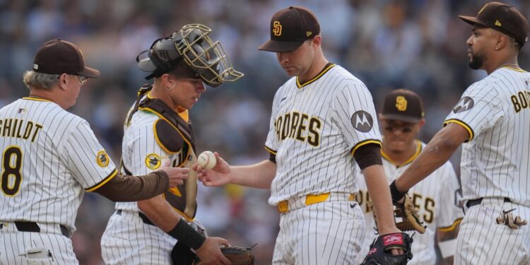 San Diego Padres starting pitcher Michael King, center, hands the ball to manager Mike Shildt (8) as he exits during the third inning of a baseball game against the Boston Red Sox Saturday, Aug. 9, 2025, in San Diego.
