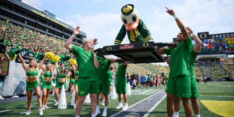 Oregon Ducks mascot being carried by students during a football game.