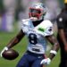 New England Patriots player in uniform holding a football.