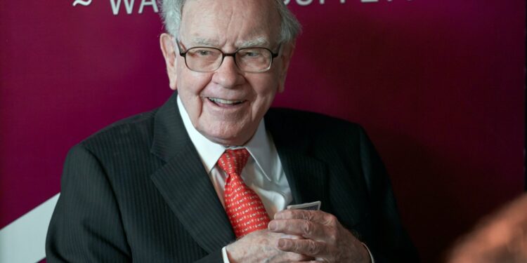 Warren Buffett holding playing cards.