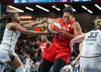 Brionna Jones grabs a rebound between two Liberty defenders during the Dream's 78-62 home win on Aug. 23, 2025.
