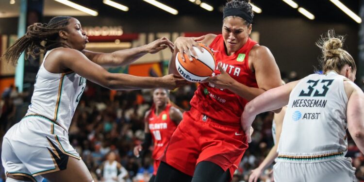Brionna Jones grabs a rebound between two Liberty defenders during the Dream's 78-62 home win on Aug. 23, 2025.