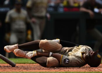 San Diego Padres player Xander Bogaerts in pain on the ground after hitting himself with his bat.