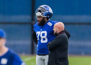 New York Giants offensive tackle Andrew Thomas speaking with head coach Brian Daboll.