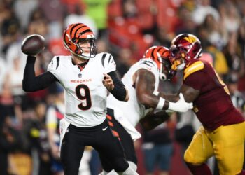 Joe Burrow, #9, throwing a football during a Bengals-Commanders game.