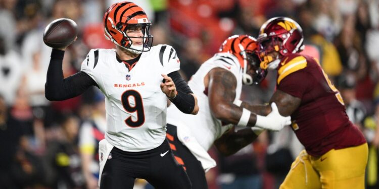 Joe Burrow, #9, throwing a football during a Bengals-Commanders game.