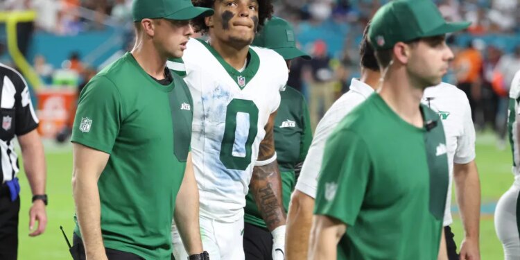 Braelon Allen walks off the field with trainers during the Jets-Dolphins game on Sept. 29, 2025.