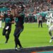 Miami Dolphins tight end Darren Waller catches a touchdown pass as Julian Hill celebrates and New York Jets' Andre Cisco defends.