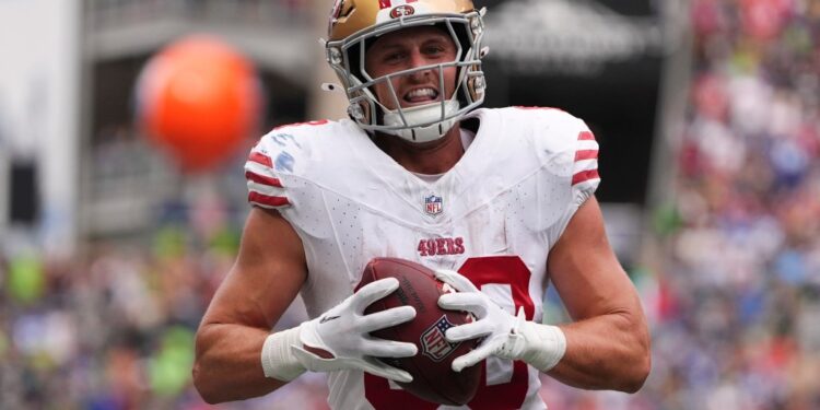 49ers player catching a football.