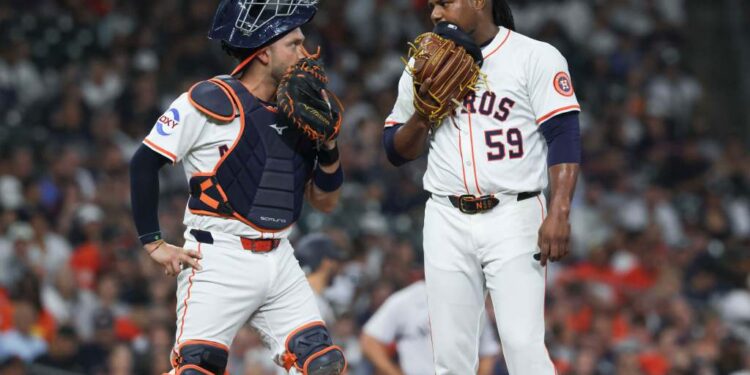 Houston Astros catcher and pitcher confer on the mound.