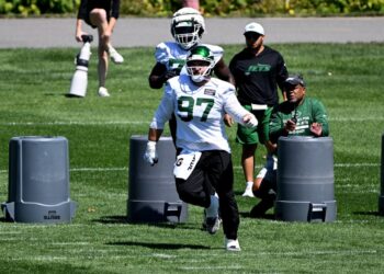 New York Jets player #97 running a drill at practice.