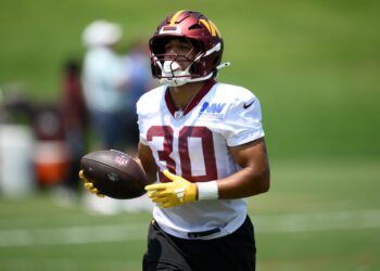 Commanders football player holding a football.