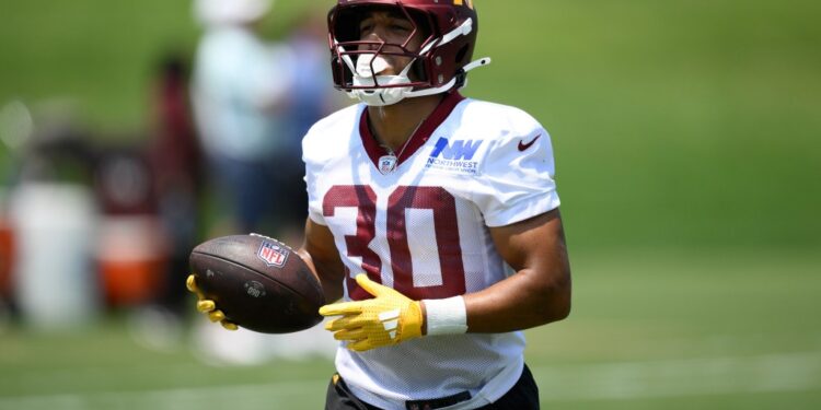 Commanders football player holding a football.