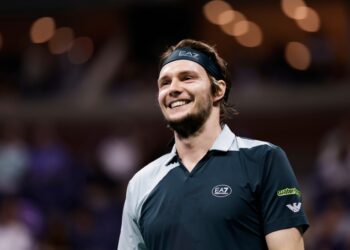 Alexander Bublik of Kazakhstan smiles during a US Open tennis match.