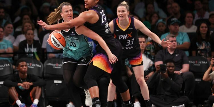 New York Liberty's Sabrina Ionescu (20) defended by Phoenix Mercury's Alyssa Thomas (25) during a basketball game.