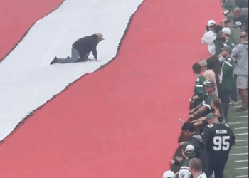 A fan gets stuck on the flag before Jets-Steelers game.