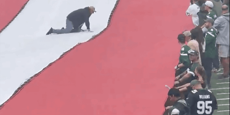 A fan gets stuck on the flag before Jets-Steelers game.