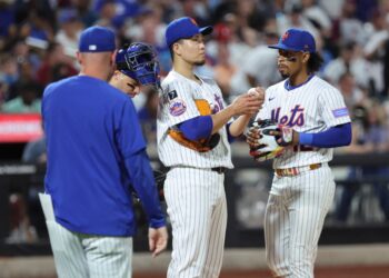 New York Mets players on the mound during a game.