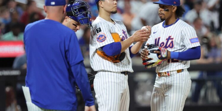 New York Mets players on the mound during a game.