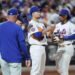 New York Mets players on the mound during a game.