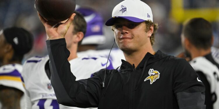 Minnesota Vikings coach holding a football.