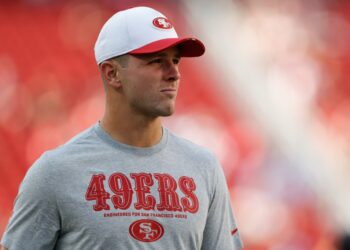 A man wearing a San Francisco 49ers shirt and cap.