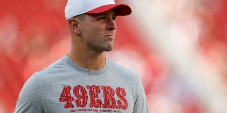 A man wearing a San Francisco 49ers shirt and cap.