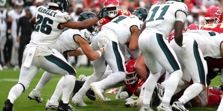 Philadelphia Eagles quarterback Jalen Hurts (1) gets a push from behind from Philadelphia Eagles tight end Grant Calcaterra (81) agains the Kansas City Chiefs in the second half during an NFL football game Sunday, Sept. 14, 2025, in Kansas City, Mo.