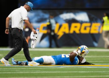 Najee Harris of the Los Angeles Chargers lying on the ground injured during an NFL football game.