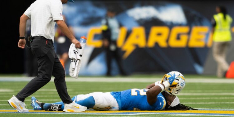 Najee Harris of the Los Angeles Chargers lying on the ground injured during an NFL football game.