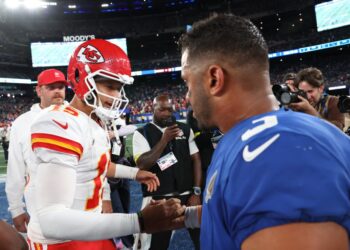 Kansas City Chiefs quarterback Patrick Mahomes and New York Giants quarterback Russell Wilson shaking hands on the field.