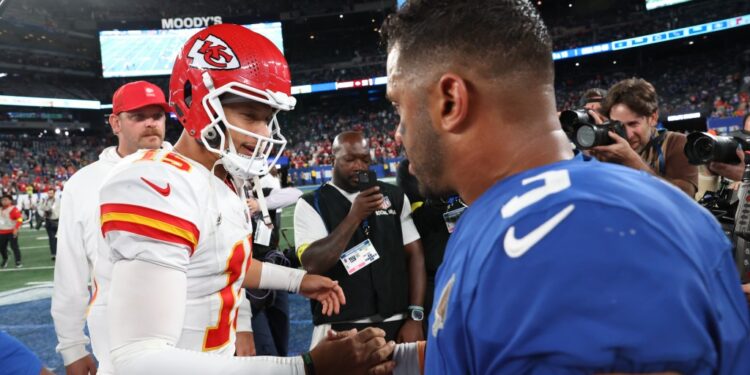 Kansas City Chiefs quarterback Patrick Mahomes and New York Giants quarterback Russell Wilson shaking hands on the field.