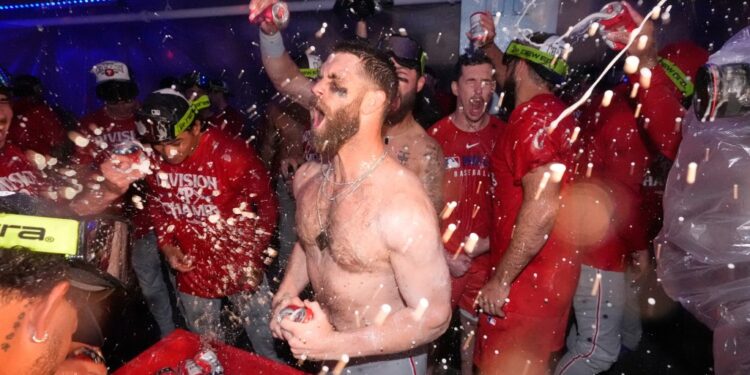 Philadelphia Phillies' Bryce Harper, center, celebrates after the Phillies clinched the NL East following their defeat of the Los Angeles Dodgers in a baseball game Monday, Sept. 15, 2025, in Los Angeles.