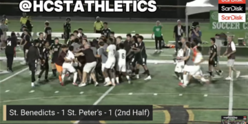 Video still of a soccer game with players celebrating on the field and the score St. Benedicts - 1 St. Peter's - 1 (2nd Half).