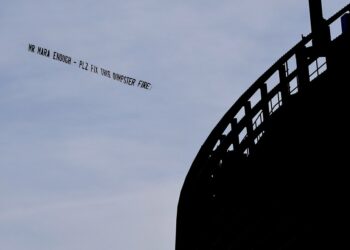 A plane towing a banner reading "MR MARA ENOUGH - PLZ FIX THIS DUMPSTER FIRE" flies over MetLife Stadium before the Giants-Saints game on Dec. 8, 2024.