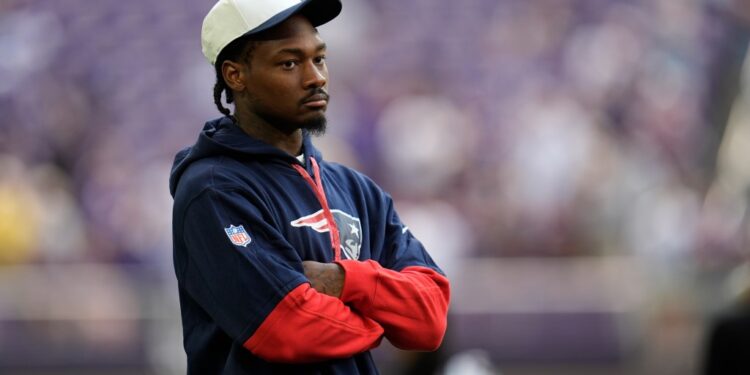 A New England Patriots player stands with his arms crossed.