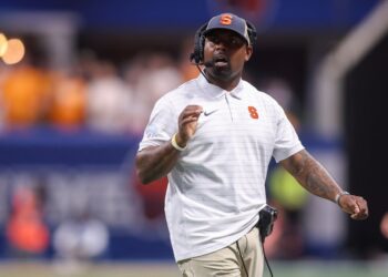 Syracuse coach with a headset at the Aflac Kickoff.