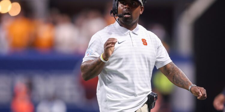 Syracuse coach with a headset at the Aflac Kickoff.