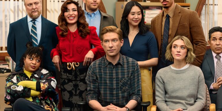 Four men and four women standing or sitting in an office together. The group appears to be posing for a group photo while they all look in different directions.