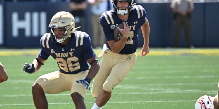 Navy quarterback Blake Horvath (11) runs with the ball as wide receiver Michael Barrow (26) blocks against the Virginia Military Institute Keydets.