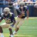 Navy quarterback Blake Horvath (11) runs with the ball as wide receiver Michael Barrow (26) blocks against the Virginia Military Institute Keydets.