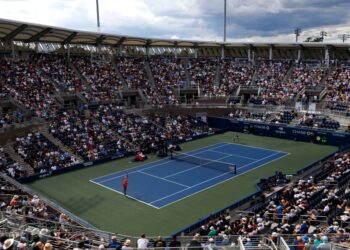 Sofia Kenin serving at a tennis match.