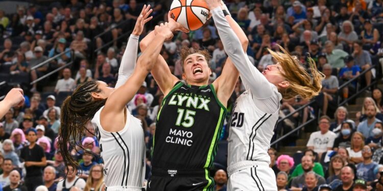 Three women's basketball players vying for the ball.
