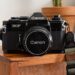 Photo of a Canon EF film camera sitting on a wooden shelf
