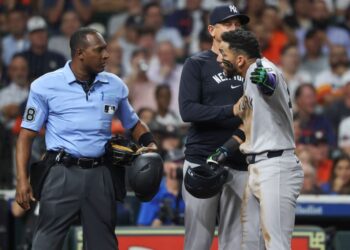 New York Yankees third baseman Jose Caballero (72) is held back by manager Aaron Boone while arguing with home plate umpire Ramon de Jesus after a call during the fourth inning against the Houston Astros at Daikin Park.
