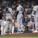 New York Yankees manager Aaron Boone and players confer on the pitcher's mound.