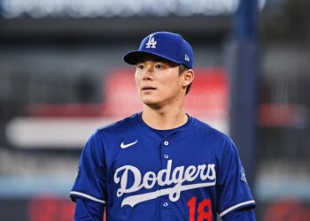 Dodgers player wearing a blue cap and jersey with number 18.