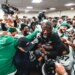 Aaron Glenn being lifted by Jets players in the locker room after their first win.